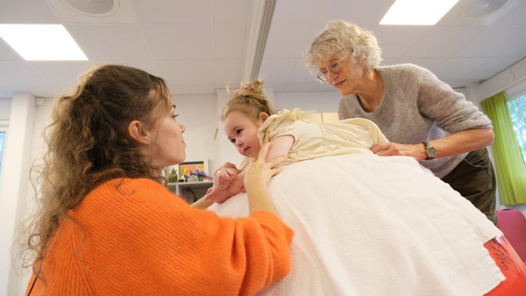 Bilde av liten jente sammen med mor og fysioterapeut